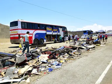 Puing-puing salah satu bus tampak berserakan di pinggir jalan tol Kota Huarmey, Peru, Senin (23/3/2015).  Insiden ini setidaknya menewaskan  34 orang tewas dan 70 luka-luka lainnya. (REUTERS/Toshiro Villanueva)