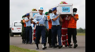 Tim SAR gabungan membawa dua peti mati jenazah penumpang pesawat AirAsia QZ8501 yang jatuh pada tanggal 28 Desember 2014  di pangkalan udara Iskandar, Pangkalan Bun, Kalteng, (19/1/2015). (REUTERS / Beawiharta)