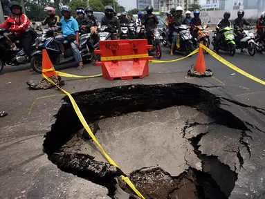 Sejumlah pengendara memperhatikan jalan yang ambles di perempatan Karet Bivak, Jakarta. Foto diambil pada Kamis (6/11/2014). (Liputan6.com/Johan Tallo) 