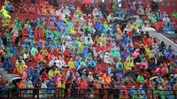 Sejumlah suporter memakai jas hujan saat menyaksikan laga perdana BRI Liga 1 2023/2024 antara Bali United melawan PSS Sleman yang berlangsung di Stadion Kapten I Wayan Dipta, Gianyar, Sabtu (1/7/2023) sore WIB. (Bola.com/Alit Binawan)