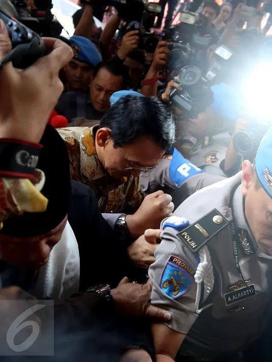 Basuki Tjahaja Purnama (Ahok) berusaha menerobos kerumunan wartawan untuk menuju pintu masuk ruang pemeriksaan Mabes Polri, Jakarta, Selasa (22/11). Ahok akan diperiksa sebagai tersangka dalam kasus dugaan penistaan agama. (Liputan6.com/Johan Tallo)
