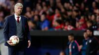 Manajer Arsenal, Arsene Wenger memegang bola saat timnya melawan Atletico Madrid pada leg kedua semifinal Liga Europa di Wanda Metropolitano, Kamis (3/5). Wenger mengaku sedih karena gagal mengakhiri kariernya di Arsenal dengan gelar. (AP/Francisco Seco)