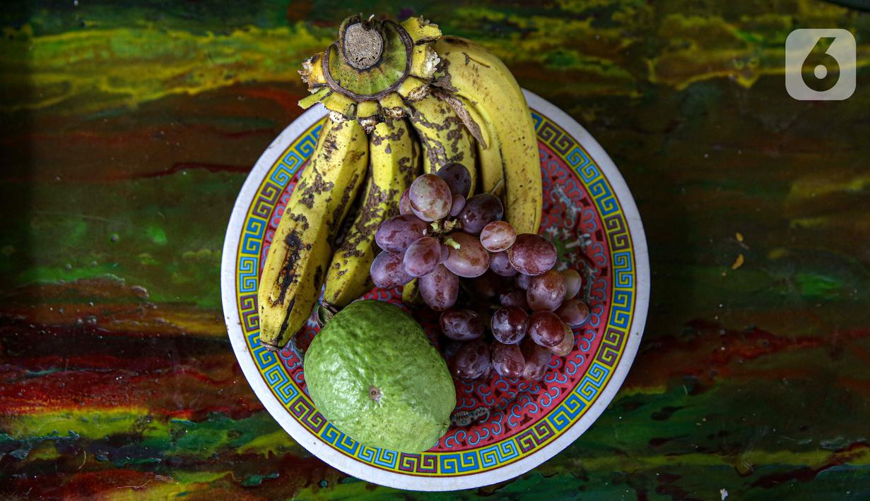 Pisang, anggur, dan jambu hasil panen dari bantaran Kali Ciliwung, Petamburan, Jakarta Pusat, Senin (24/5/2021). Pemanfaatan lahan bantaran Kali Ciliwung untuk bertani bersama dilakukan sebagai upaya memenuhi kebutuhan hidup di tengah keterbatasan lahan. (Liputan6.com/Faizal Fanani)