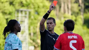 Wasit Luca Zufferli memberikan kartu merah kepada pemain Portugal, Rafael Leao, kiri, dan pemain Chile, Ivan Roman, selama pertandingan persahabatan internasional antara Portugal dan Chile di Oeiras, di luar Lisbon, Sabtu, 6 Juni 2026. (AP Photo/Armando Franca)