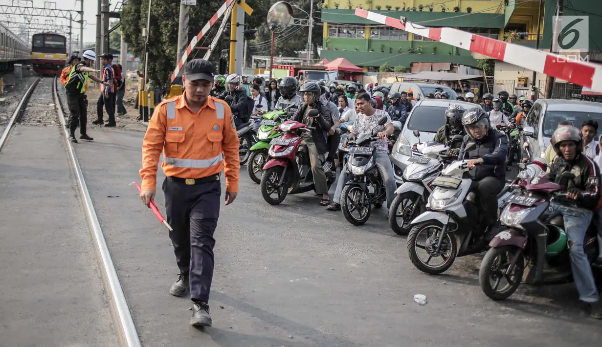 Suasana saat petugas PT KAI Daop I menggelar sosialisasi tertib berlalu lintas di pintu perlintasan sebidang kawasan Bukit Duri, Jakarta, Selasa (17/9/2019). Sosialisasi dilakukan karena banyaknya kecelakaan akibat ketidakdisiplinan pengendara. (Liputan6.com/Faizal Fanani)