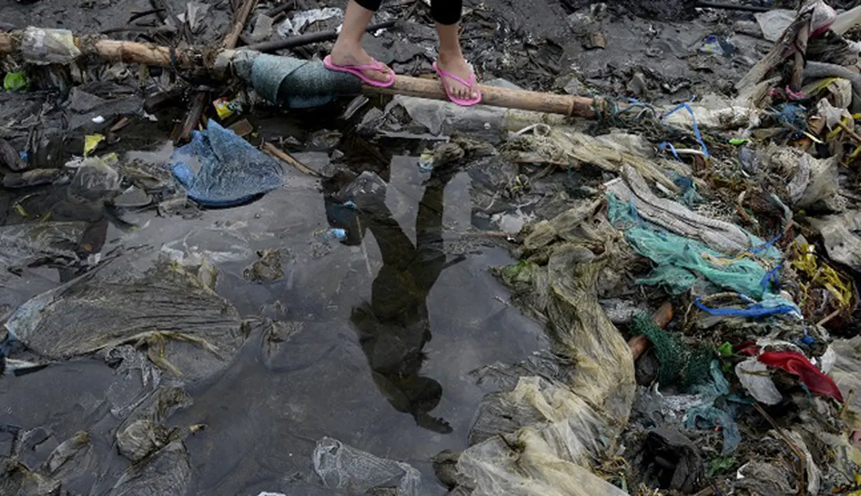Warga berjalan di atas sampah yang menumpuk di Manila Bay pada (19/9/2015). Kegiatan membersihkan pantai ini untuk memperingati International Coastal Cleanup Day atau Hari membersihkan pantai internasional. (AFP PHOTO/NOEL CELIS)