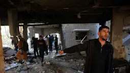 Kementerian Kesehatan Gaza dalam pernyataan tertulis pada Kamis (15/1/2026) melaporkan militer Israel masih melancarkan serangan udara di sejumlah wilayah. Tampak dalam foto, warga Palestina memeriksa rumah yang hancur setelah serangan militer Israel terhadap rumah keluarga al-Houli, di mana empat orang dilaporkan tewas, di sebelah barat Deir al-Balah, di Jalur Gaza tengah pada Jumat 16 Januari 2026. (BASHAR TALEB/AFP)