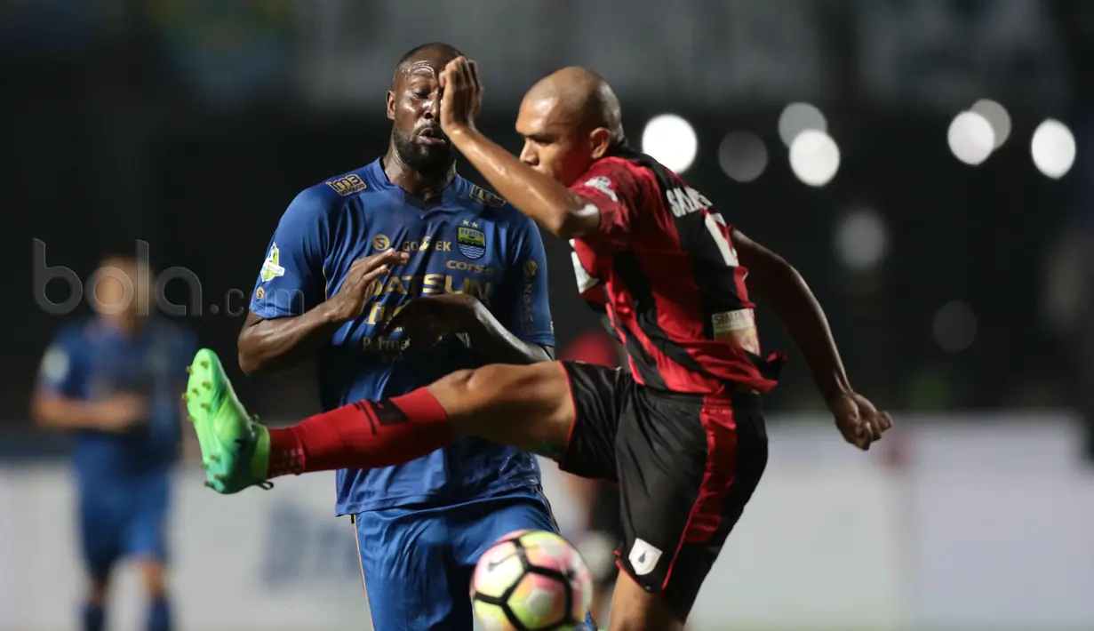 Pemain Persipura Jayapura, Ricardo Salampessy membuat bola dari kejaran Carlton Cole pada laga Liga 1 2017 di Stadion GBLA, Bandung, Minggu (7/5/20170). Persib menang 1-0. (Bola.com/Nicklas Hanoatubun)