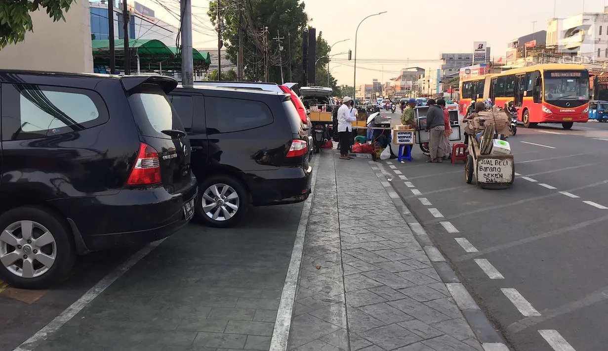 Kendaraan dan PKL menutup sebagian badan trotoar di kawasan Jatinegara, Jakarta, Senin (24/9). Kondisi trotoar yang telah diperlebar Pemprov DKI kini dipenuhi PKL dan parkir liar mengganggu kenyamanan pejalan kaki. (Liputan6.com/Immanuel Antonius)