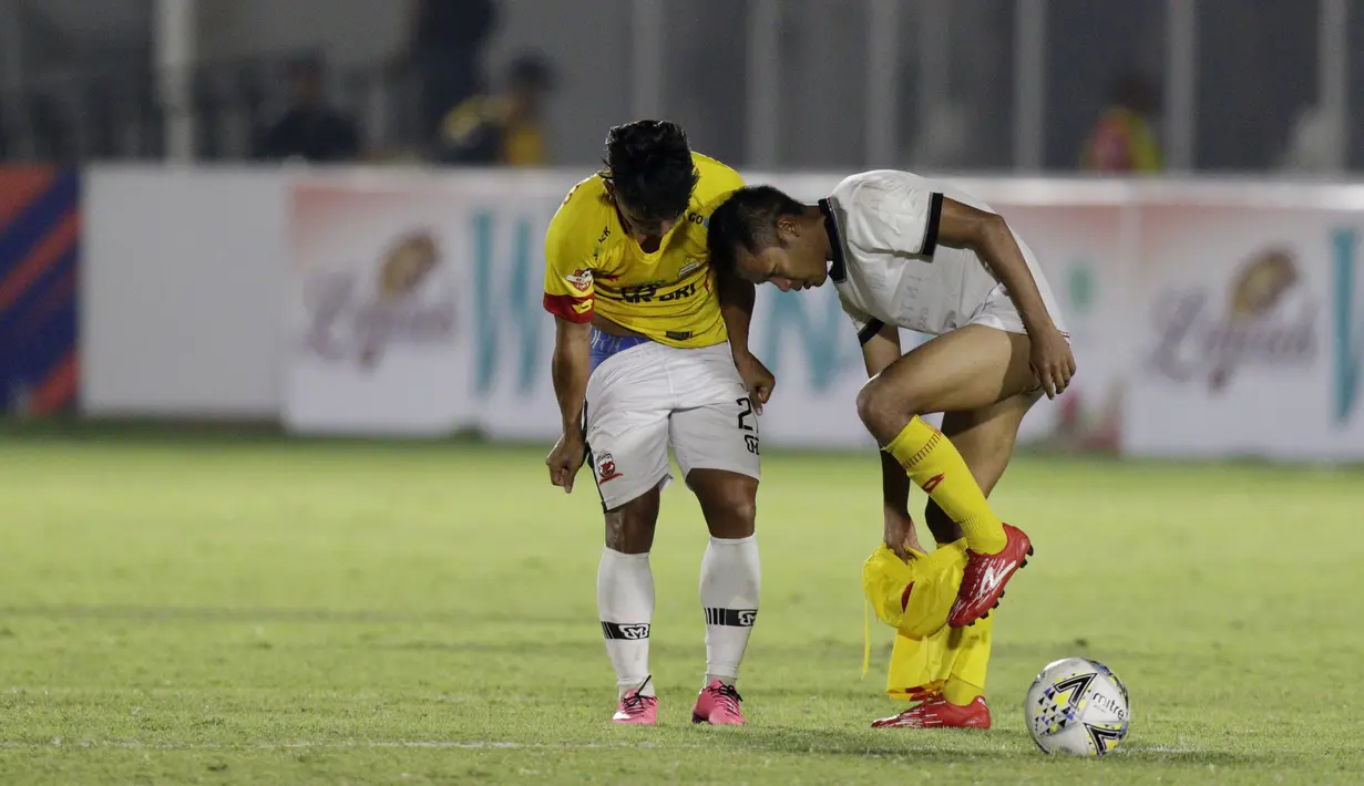 Gelandang Madura United, Andik Vermansah, bertukar jersey dan celana dengan gelandang Bhayangkara FC, Wahyu Suboseto, pada laga Liga 1 2019 di Stadion Madya, Jakarta, Senin (5/8). Kedua tim bermain imbang 1-1. (Bola.com/M iqbal Ichsan)