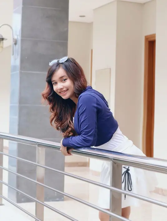 Penyanyi kelahiran Pasuruan ini tampil segar saat menggunakan pakaian berwarna biru dan rok putih ini. Rambutnya yang tampak sangat mencolok dengan warna kecoklatan ditambah aksesoris kacamata. Senyumannya tak pernah hilang. (Liputan6.com/IG/@tasya_ratu_gopo)