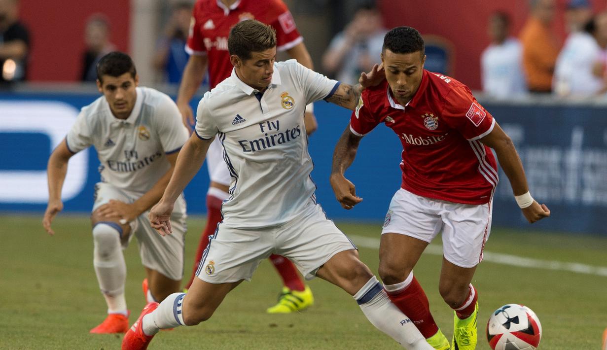 Pemain Real Madrid, James Rodriguez, berusaha menghentikan pergerakan pemain Bayern Munchen, Thiago Alcantara (kanan), pada laga lanjutan International Champions Cup 2016 di MetLife Stadium, New Jersey, AS, Kamis (4/8/2016) pagi WIB. (AFP/Don Emmert)
