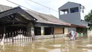 Warga melintasi banjir yang merendam perumahan Ciledug Indah, Tangerang, Banten, Kamis (2/1/2020). Memasuki hari kedua, kondisi perumahan tersebut masih tergenang banjir setinggi dada orang dewasa. (Liputan6.com/Angga Yuniar)