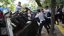 Sejumlah motor yang parkir di sepanjang trotoar kawasan Kebon Sirih, Jakarta diangkut petugas, Kamis (18/1). Puluhan motor diamankan serta digembosi dalam penertiban tersebut karena menutupi jalur pedestrian. (Liputan6.com/Immaniel Antonius)