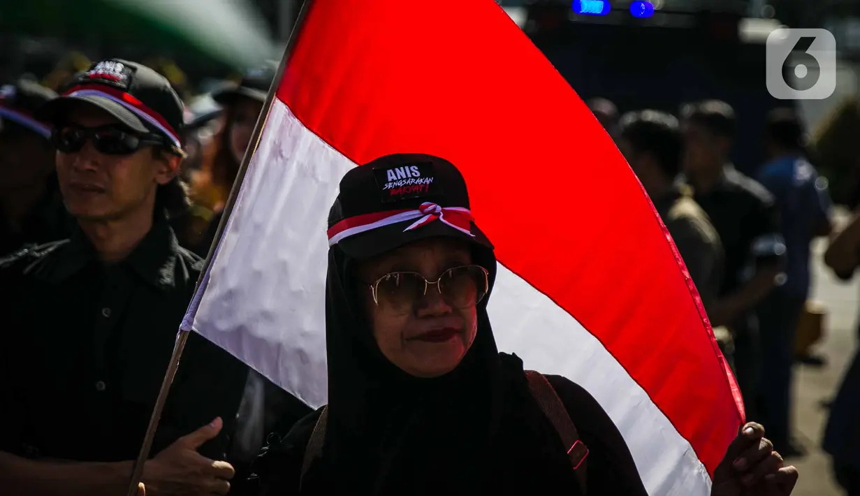 Massa yang menamakan diri Suara Rakyat Bersatu membawa bendera Merah Putih saat berunjuk rasa di depan Balai Kota DKI Jakarta, Selasa (14/1/2020). Mereka menuntut Gubernur DKI, Anies Baswedan turun dari jabatannya, karena dinilai gagal dalam mengatasi banjir di Jakarta. (Liputan6.com/Faizal Fanani)