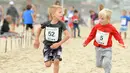 Ekspresi dua anak saat berpartisipasi dalam 'Tot Trot' selama Nautica Malibu Triathlon di Pantai Zuma di Malibu, California (14/9). (Noel Vasquez / Getty Images untuk Nautica / AFP)