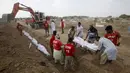 Relawan menguburkan jenazah korban tewas akibat gelombang panas saat pemakaman massal di Karachi, Pakistan, Jumat (26/6/2015). Lebih dari 1.150 orang tewas akibat gelombang panas. (REUTERS/Akhtar Soomro)