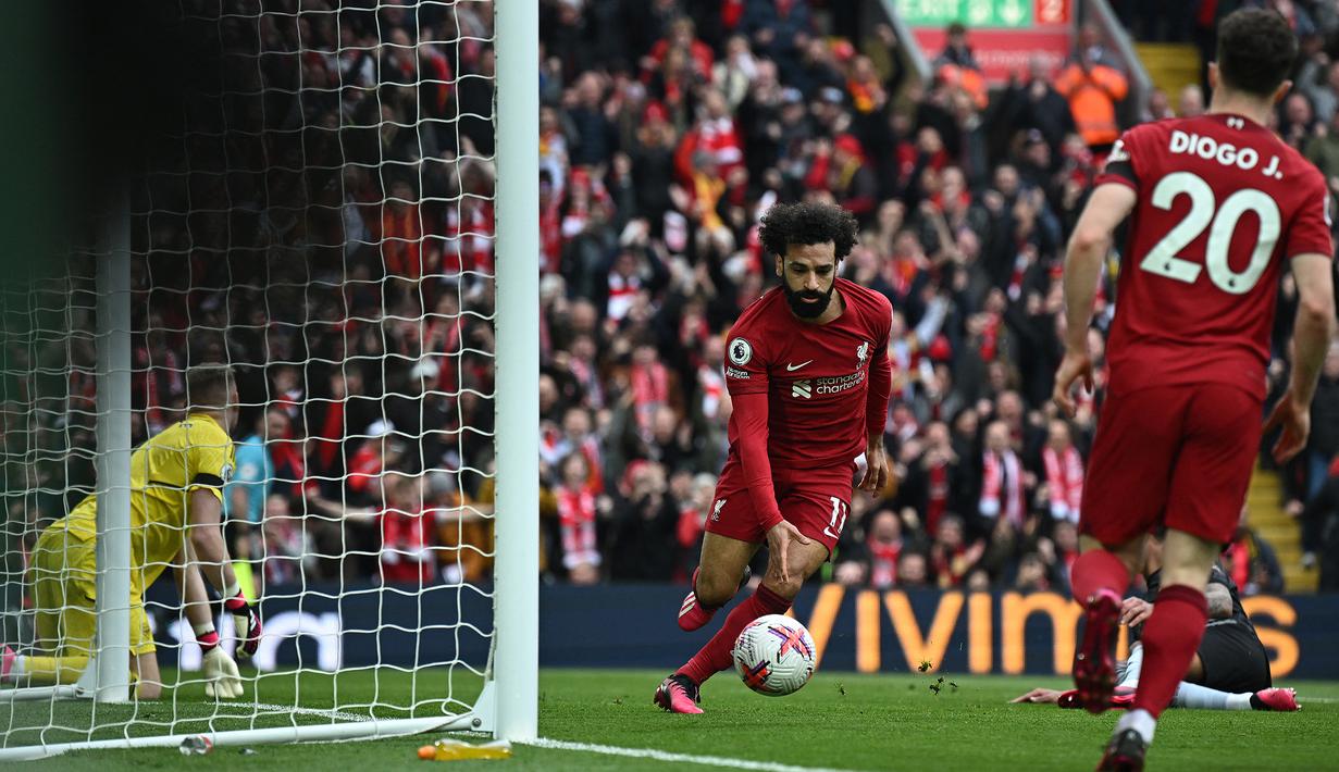 Selebrasi striker Liverpool, Mohamed Salah setelah mencetak gol pertama timnya ke gawang Arsenal pada laga lanjutan pekan ke-30 Liga Inggris 2022/2023 di Anfield Stadium, Liverpool, Minggu (9/4/2023) malam WIB. (AFP/Paul Ellis)