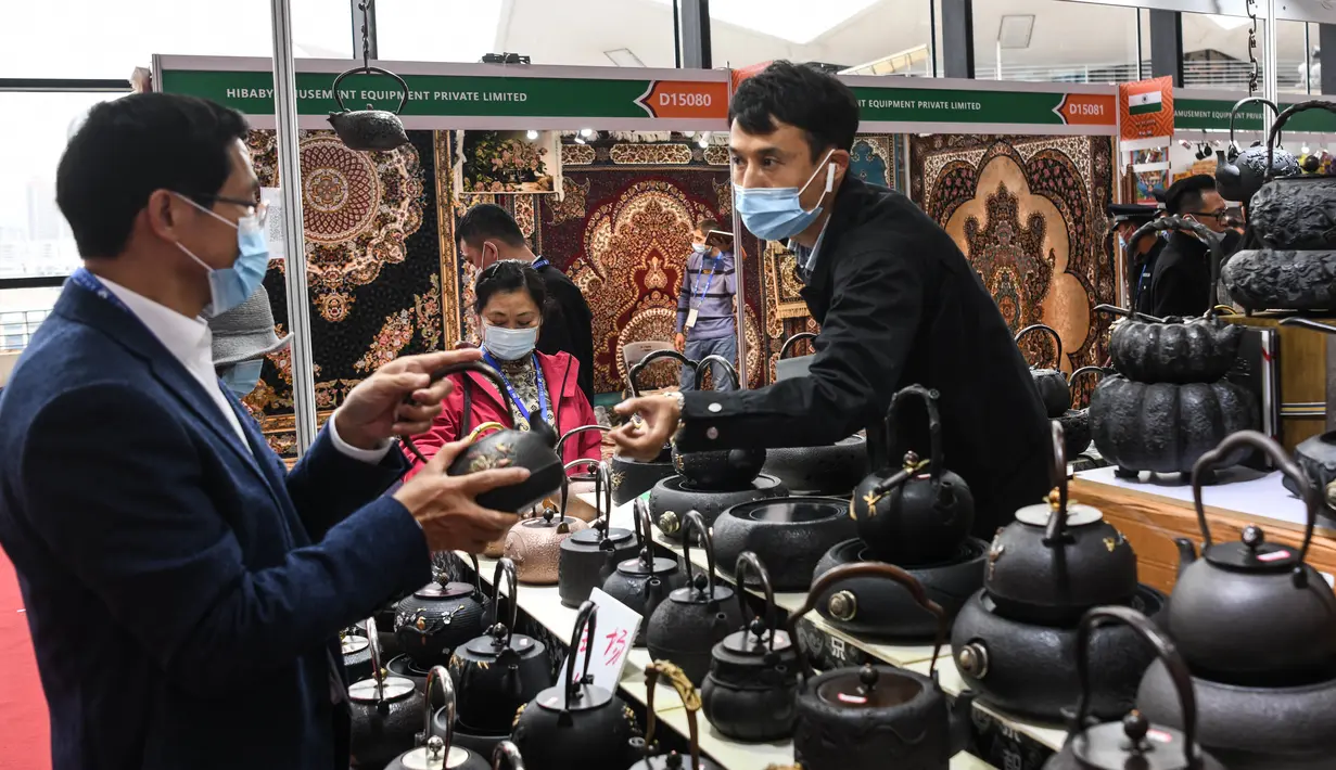 Pengunjung (kiri) membeli teko teh di area ekshibisi Sabuk dan Jalur Sutra di China-ASEAN Expo ke-17, Nanning International Convention and Exhibition Center, Guangxi, China, 27 November 2020. China-ASEAN Expo ke-17 dan KTT Bisnis dan Investasi China-ASEAN dibuka pada (27/11). (Xinhua/Zhang Ailin)