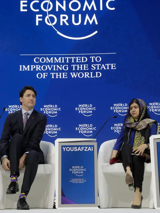 Peraih Nobel Malala Yousafzai mengamati PM Kanada Justin Trudeau disela acara tahunan World Economic Forum (WEF) di Davos, Swiss, Kamis (25/1). PM Trudeau mencuri perhatian dengan kaus kaki yang motif bebek berwarna kuning dan ungu. (AP/Markus Schreiber)