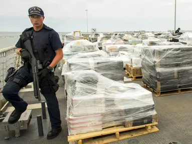 Seorang anggota US Coast Guard berjaga di dekat 33 ton kokain senilai sekitar Rp 13 triliun lebih, di California, Senin (10/8/2015). Kokain tersebut disita dari kapal semi-sumbersible di timur Samudera Pasifik pada Kamis (6/8). (REUTERS/Mike Blake)