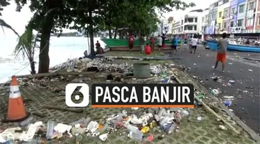 Material batu dan sampah berserakan di sepanjang jalan kawasan Megamas, Manado, pasca diterjang banjir rob pada Minggu (17/1) sore kemarin.