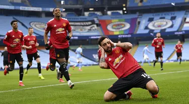 Pemain Manchester United Bruno Fernandes melakukan selebrasi usai mencetak gol ke gawang Manchester City pada pertandingan Liga Inggris di Etihad Stadium, Manchester, Inggris, Minggu (7/3/2021). Manchester United mempermalukan Manchester City dengan skor 2-0. (Laurence Griffiths/Pool via AP)