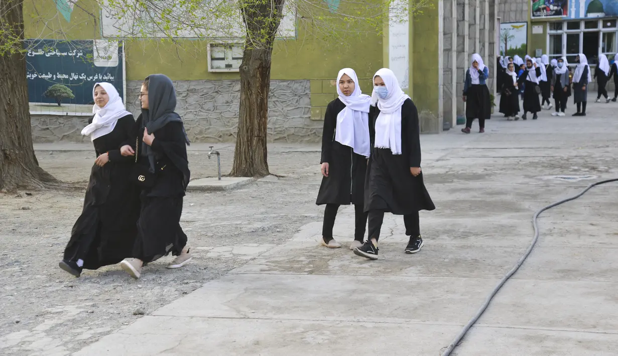 Anak perempuan tiba di sekolah mereka di Kabul (23/3/2022). Penutupan sekolah memicu kebingungan dan patah hati atas peristiwa tersebut. pembalikan kebijakan oleh kelompok Taliban. (AFP/Ahmad Sahel Arman)
