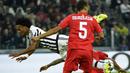 Pemain Juventus, Juan Cuadrado terjatuh saat berebut bola dengan pemain Sevilla pada laga Liga Champions di Stadion Juventus, Italia, Kamis (1/10/2015). (AFP Photo/Olivier Morin)
