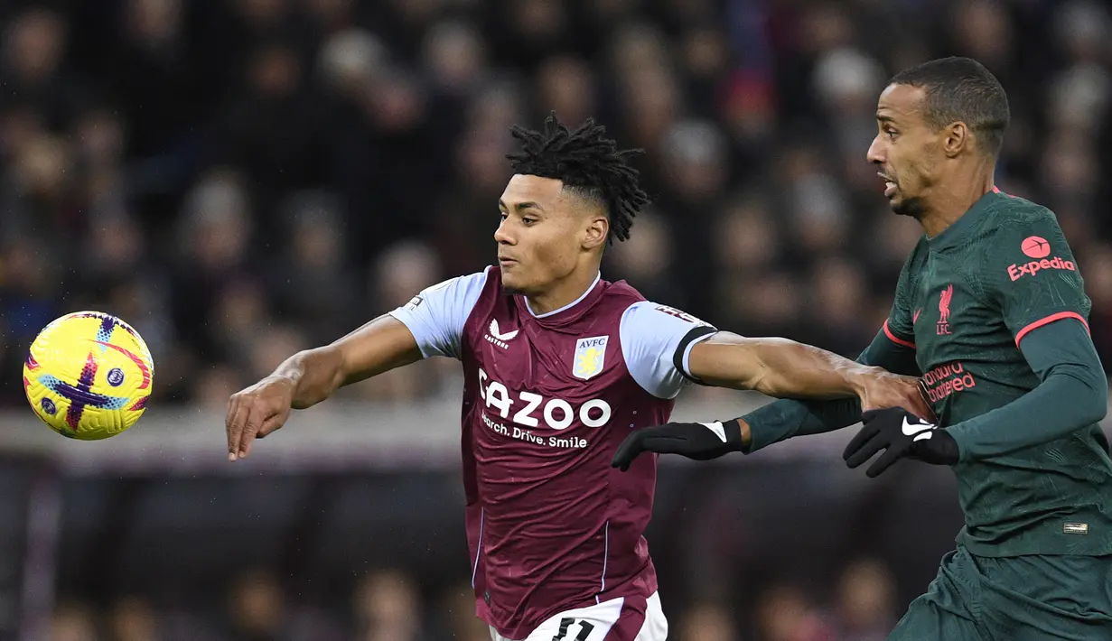 Striker Aston Villa, Ollie Watkins (kiri) berusaha melepaskan diri dari penjagaan bek Liverpool, Joel Matip pada laga Liga Inggris 2022/2023 di Villa Park, Birmingham (26/12/2022). Ollie Watkins yang didatangkan dari Brentford pada awal musim 2020/2021 menjadi top skor Aston Villa di Liga Inggris 2022/2023. Dari 32 laga, ia telah mencetak 14 gol dan 6 assist. (AFP/Oli Scarff)
