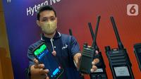Teknisi menunjukkan dua perangkat radio dalam peluncuran seri mobile radio profesional di Indonesia yang dirancang untuk kelancaran operasional bisnis baik indoor maupun outdoor, Jakarta (1/7/2022). (Liputan6.com/HO/Job)