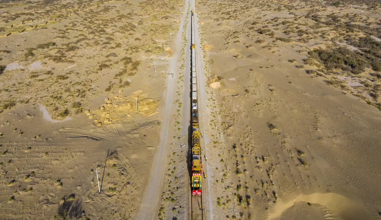 Para pekerja memasang rel di lokasi konstruksi jaringan kereta Hotan-Ruoqiang di Daerah Otonom Uighur Xinjiang, China, 25 September 2020. Dengan total panjang sekitar 825 kilometer, jaringan kereta itu merupakan bagian penting dari loop kereta di Lembah Tarim. (Xinhua/Hu Huhu)