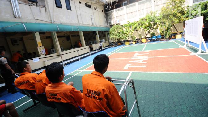 Tahanan menunggu giliran untuk mencoblos di TPS 15 Rutan Polda Metro Jaya, Jakarta, Rabu (17/4). Mereka terlihat mengenakan seragam tahanan berwarna oranye. (Liputan6.com/Herman Zakharia)