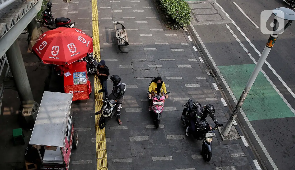 Banyaknya pedagang yang memanfaatkan trotoar untuk menjajakan barang atau berjualan serta pengendara motor untuk memarkir kendaraannya membuat trotoar menjadi sempit dan tidak nyaman bagi pejalan kaki. (Liputan6.com/Angga Yuniar)