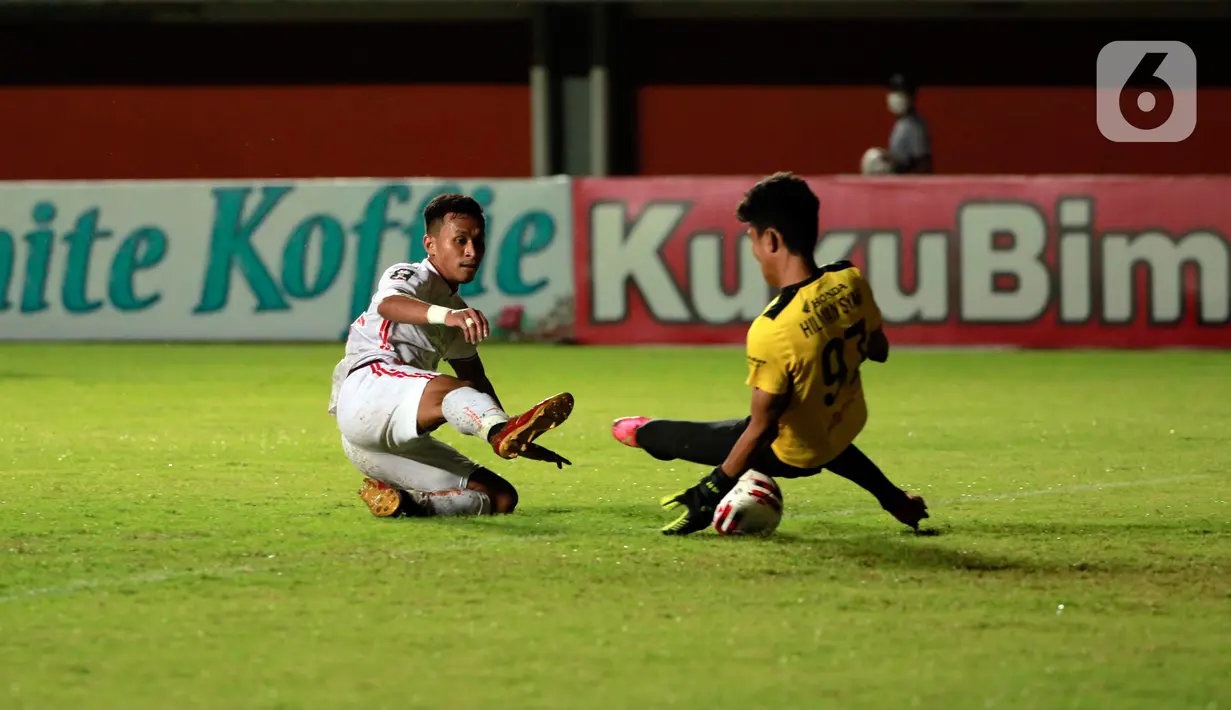 Kiper PSM Makassar, Hilman Syah (kanan) berhasil menghadang tendangan pemain Persija Jakarta, Osvaldo Ardiles Haay (kanan) dalam pertandingan semifinal Piala Menpora 2021 di Stadion Maguwoharjo, Sleman, Kamis (15/4/2021). PSM Makassar vs Persija Jakarta bermain imbang 0-0. (Bola.com/Ikhwan Yanuar)