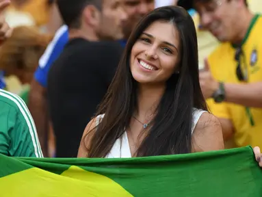 Seorang fans cantik asal Brasil tersenyum manis saat menonton semifinal sepak bola antara Brasil melawan Honduras pada ajang Olimpiade Rio 2016 di Stadion Maracana, Rio de Janeiro, Brasil, (17/8/2016). (AFP/Martin Bernetti)