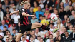 Pemain Manchester City, Erling Haaland (kiri), berusaha mengontrol bola dalam pertandingan pekan ke-34 Premier League 2022/2023 melawan Fulham yang berlangsung di Craven Cottage, Minggu (30/4/2023). Satu gol Haaland ke gawang Fulham membuat dirinya semakin kokoh di puncak daftar pencetak gol sementara dengan 34 gol. (AFP/Adrian Dennis)