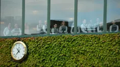 Staff restoran menyaksikan aksi pemain Serbia, Novak Djokovic saat berlatih sebelum melawan pemain Inggris Raya,  James Ward  pada Tenis Wimbledon Championships 2016 di The All England Lawn Tennis Club, Wimbledon,  London, (27/6/2016). (AFP/ Glyn Kirk)