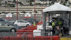 Mobil-mobil menunggu untuk mendapatkan vaksin COVID-19 di pusat vaksinasi drive-thru di City College of San Francisco di San Francisco, Senin (1/2/2021). Ketika pasokan vaksin COVID-19 meningkat, UC San Francisco memperluas upaya vaksinasi kepada mereka yang paling berisiko. (AP Photo/Jeff Chiu)
