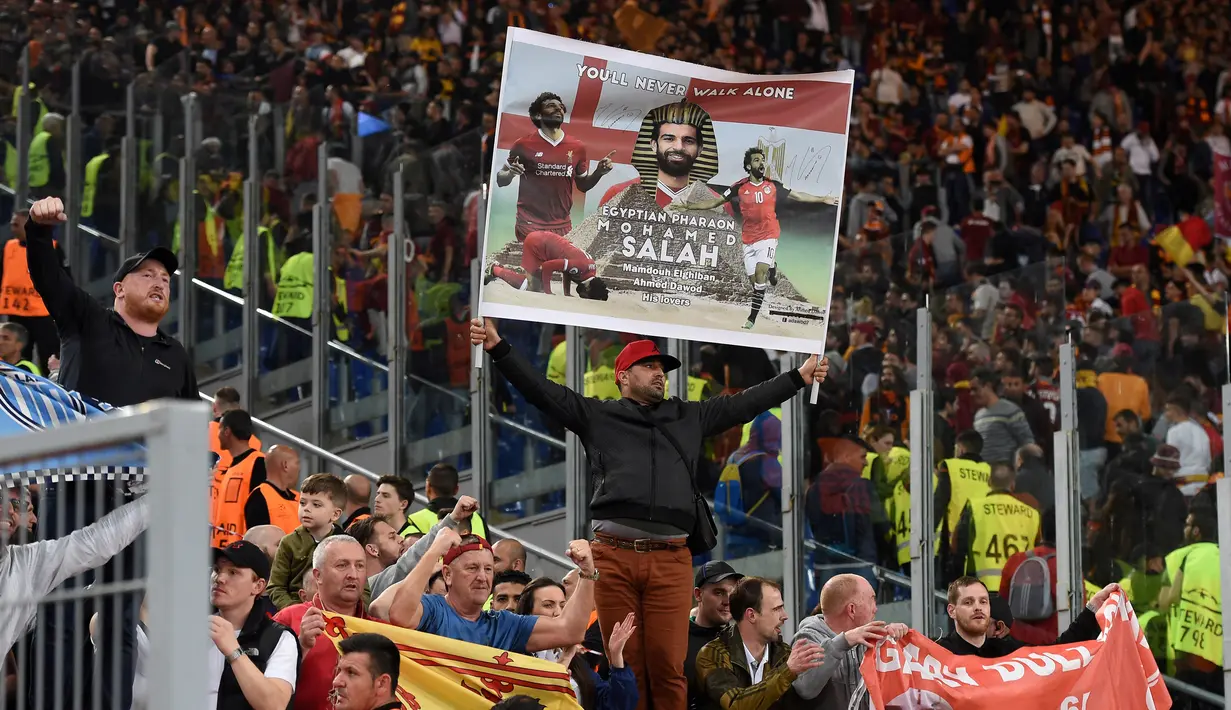 Seorang suporter Liverpool membentangkan poster penyerang Mohamed Salah saat mendukung tim kesayangannya bertanding melawan AS Roma pada leg kedua semifinal Liga Champions di Stadion Olimpiade, Roma (2/5). (AFP Photo/Paul Ellis)