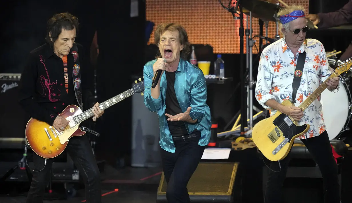 Ronnie Wood (kiri), Mick Jagger (tengah), dan Keith Richards (kanan) tampil di atas panggung saat konser Sixty di Berlin, Jerman, 3 Agustus 2022. Mick Jagger mengatakan kepada 22 ribu penggemar bahwa band tersebut telah minum beberapa gelas schnapps malam sebelumnya untuk menghormati Charlie Watts. (AP Photo/Michael Sohn)
