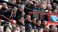 Pelatih sementara Manchester United, Ryan Giggs (berdasi) duduk di samping Paul Scholes menyimak serius permainan timnya saat berlaga melawan Norwich City  di Old Trafford, Inggris (27/4/2014). (REUTERS/Nigel Roddis) 