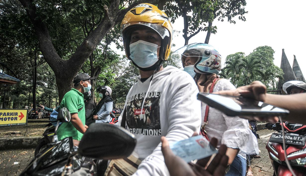 Petugas memeriksa KTP wisatawan sebelum masuk ke Taman Margasatwa Ragunan, Jakarta, Jumat (14/5/2021). Taman Margasatwa Ragunan membatasi jumlah wisatawan dengan kapasitas 30 persen. (merdeka.com/Iqbal S. Nugroho)