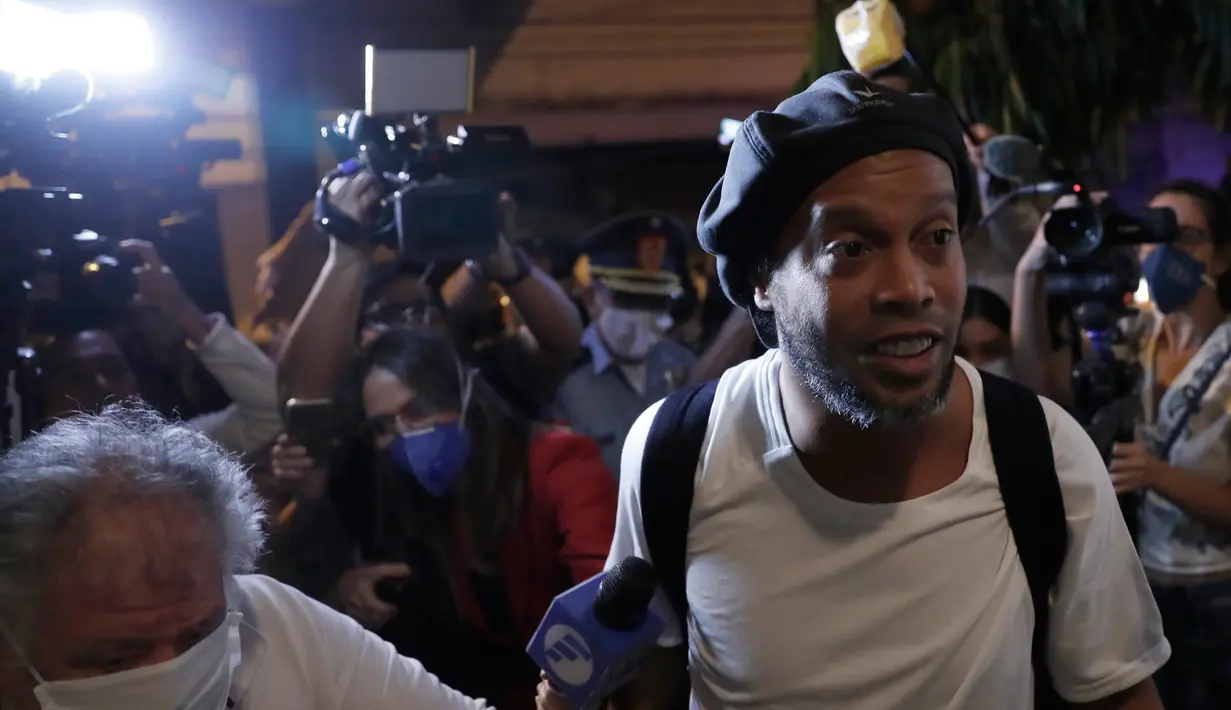 Awak media mengambil gambar mantan pemain timnas Brasil, Ronaldinho setibanya di sebuah hotel untuk menjalani tahanan rumah di Asuncion, Selasa (7/4/2020). Ronaldinho dan kakaknya dijebloskan ke penjara pada 5 Maret 2020 lantaran menggunakan paspor palsu saat masuk ke Paraguay. (AP/Jorge Saenz)