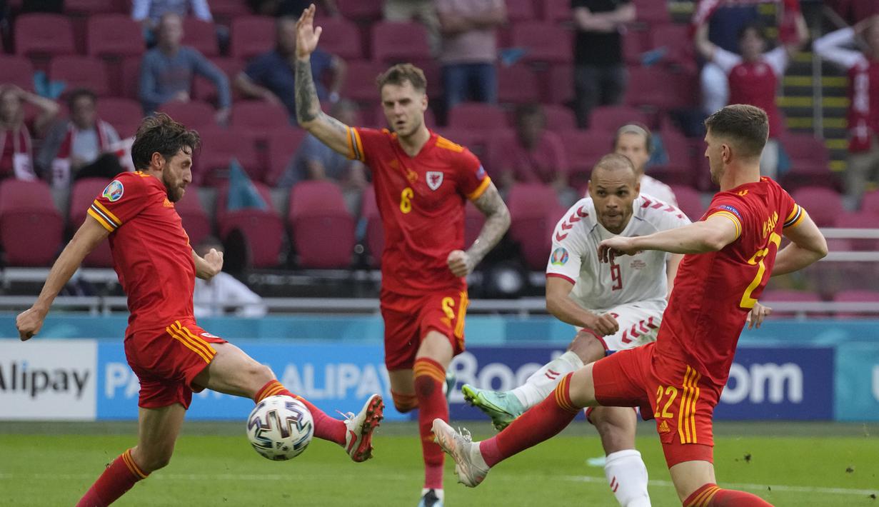 Striker Martin Braithwaite berhasil menutup laga dengan gol keempat usai melepaskan tendangan di antara dua bek Wales yang gagal diantisipasi kiper Danyy Ward. Denmark menang 4-0 dan lolos ke babak perempatfinal. (Foto: AP/Pool/Peter Dejong)