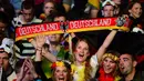 Senyum gembira fans atas kemenangan Jerman pada pertandingan final Piala Dunia 2014, Brasil, Senin (14/7/14). (AFP/JOHN MACDOUGALL)