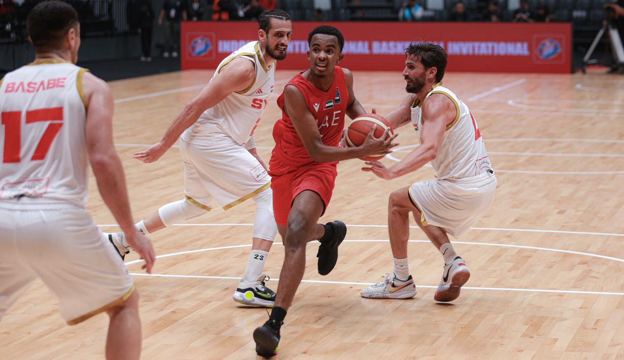 Pemain Timnas Basket Uni Emirat Arab, Hamid Abdullateef Albreiki (tengah) berusaha melewati pemain Timnas Basket Suriah pada laga hari pertama Indonesia International Basketball Invitational 2023 melawan Suriah di Indonesia Arena, Senayan, Jakarta, Rabu (02/08/2023). Laga dimenangankan oleh UEA dengan skor 63-61. (Bola.com/Bagaskara Lazuardi)