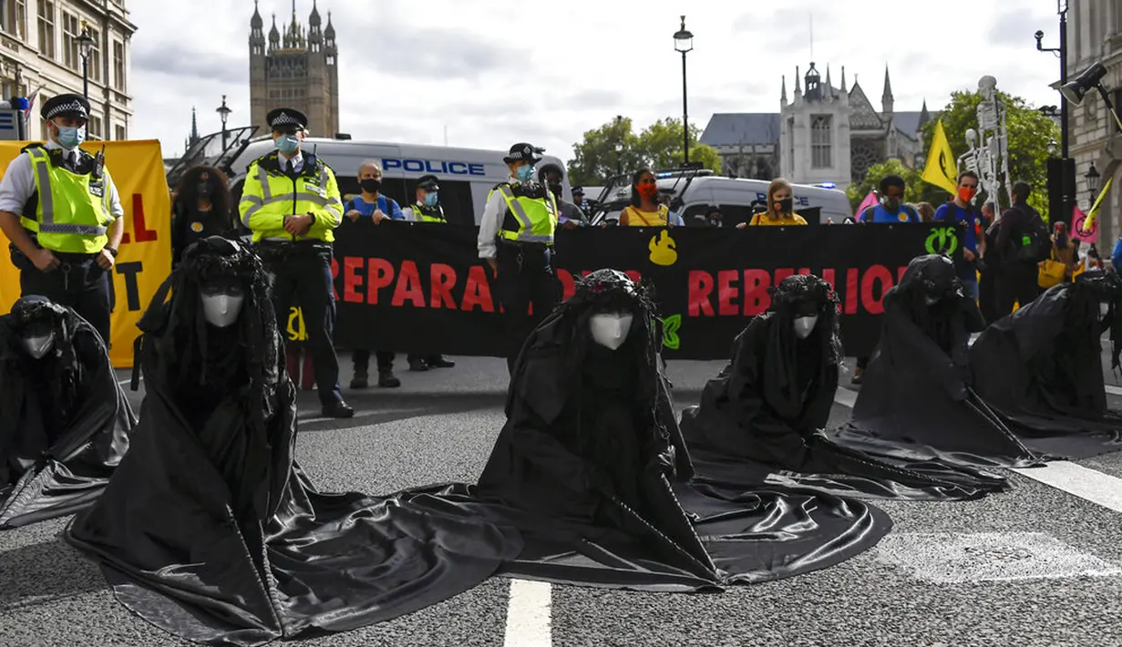 Aktivis Extinction Rebellion berbaris di sepanjang Parliament Street sebagai bagian dari protes perubahan iklim di London, Inggris, Selasa (8/9/2020). Menggelar aksi di tengah pandemi COVID-19, para aktivis mengenakan masker selama protes berlangsung. (AP Photo/Alberto Pezzali)