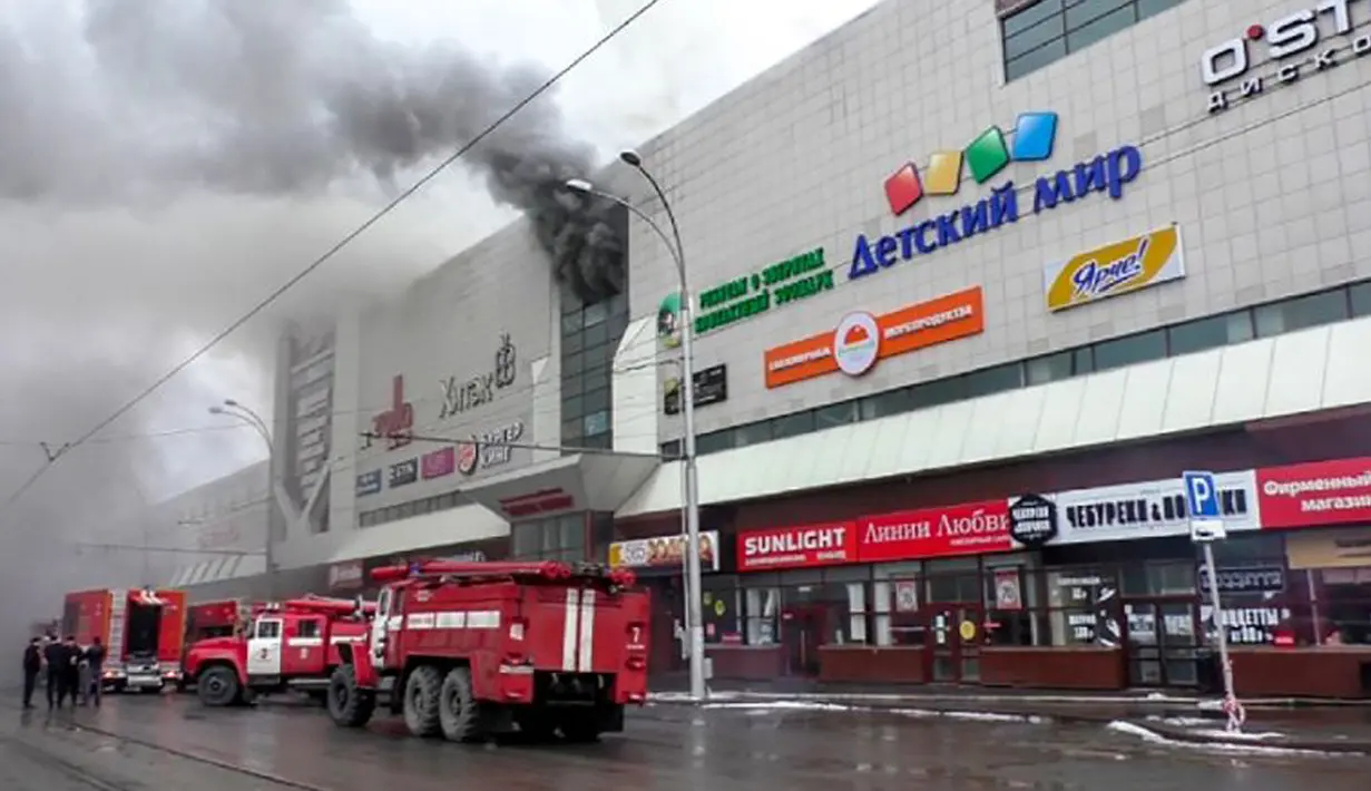 Kendaraan petugas darurat di lokasi kebakaran yang melanda pusat perbelanjaan Winter Cherry di Kota Kemerovo, Siberia, Rusia, Minggu (25/3). Saksi mata melaporkan bahwa alarm kebakaran di mal tidak berfungsi. (HO/RUSSIAN EMERGENCY SITUATIONS MINISTRY/AFP)