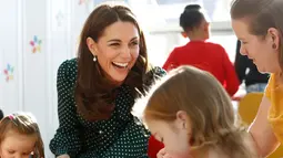 Kate Middleton tertawa saat bermain dengan pasien anak di Rumah Sakit Anak Evelina di London, Inggris (11/12).Kate dan suaminya pangeran William mengajak para pasien anak untuk merayakan Natal. (Chris Jackson/Pool via AP)